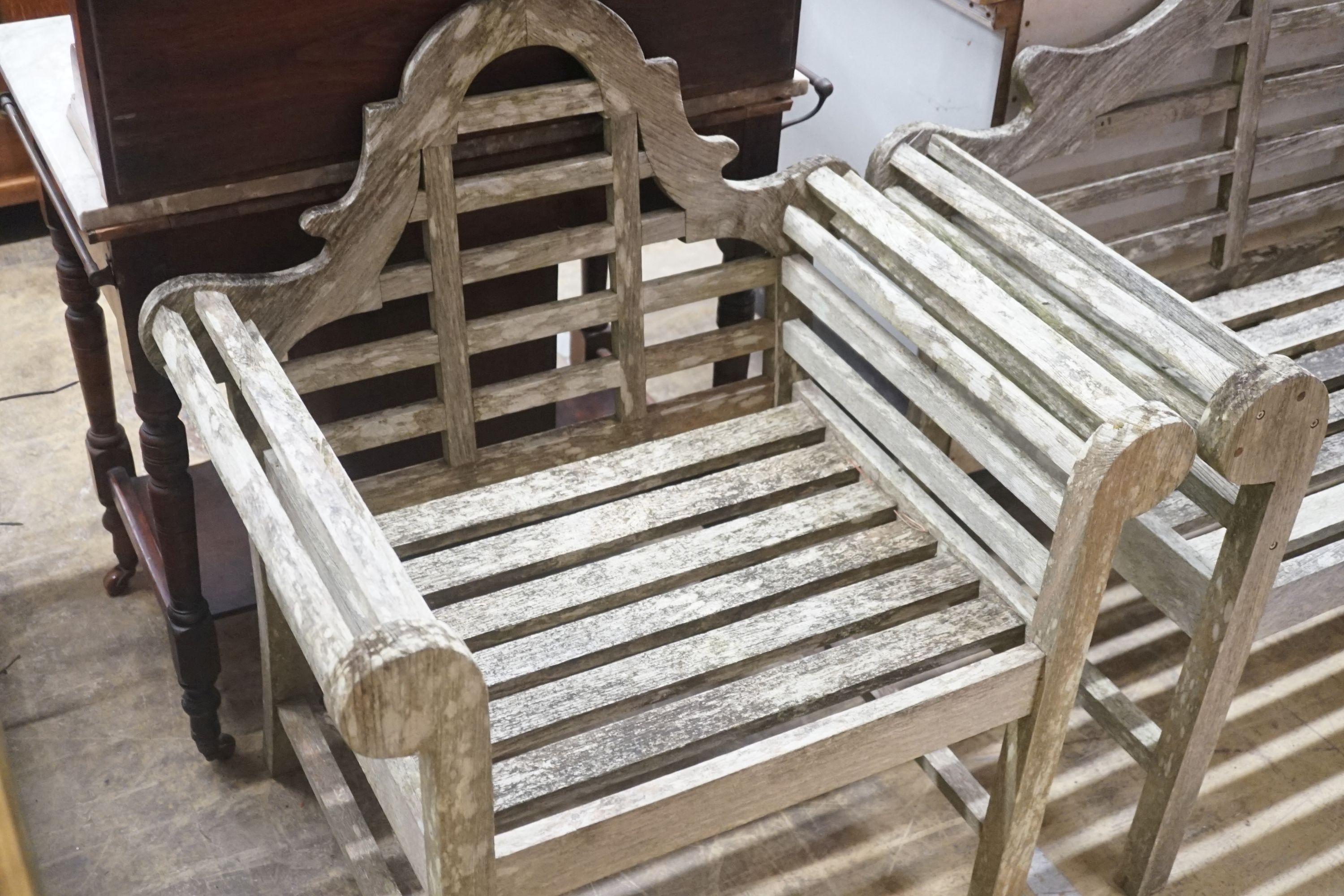 A Lutyens style weathered teak garden bench, width 164cm depth 56cm height 106cm, and two chairs